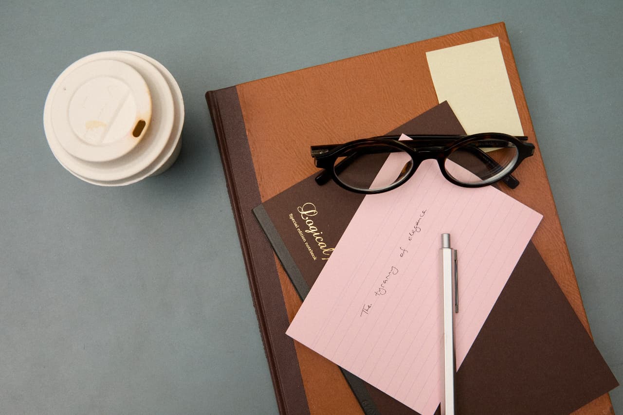Warm leather notebooks, glasses and a coffee on a desk